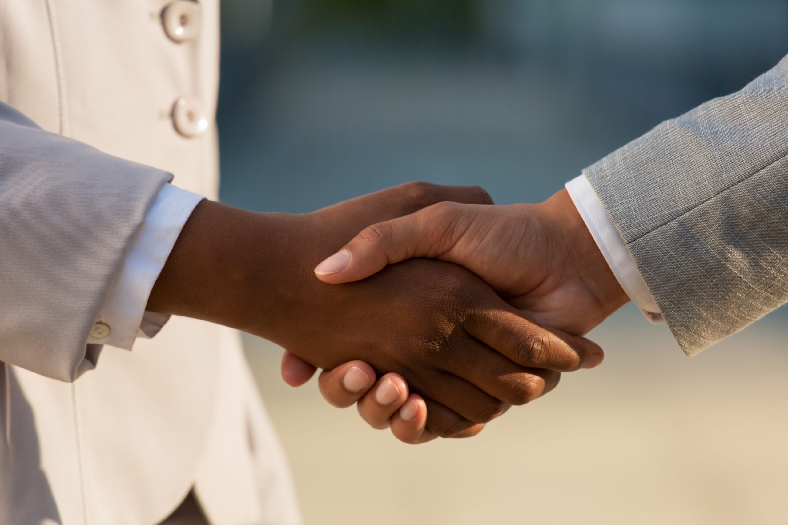 Dark skinned businesswoman shaking hands with male colleague. Closeup of business people handshake. Agreement concept